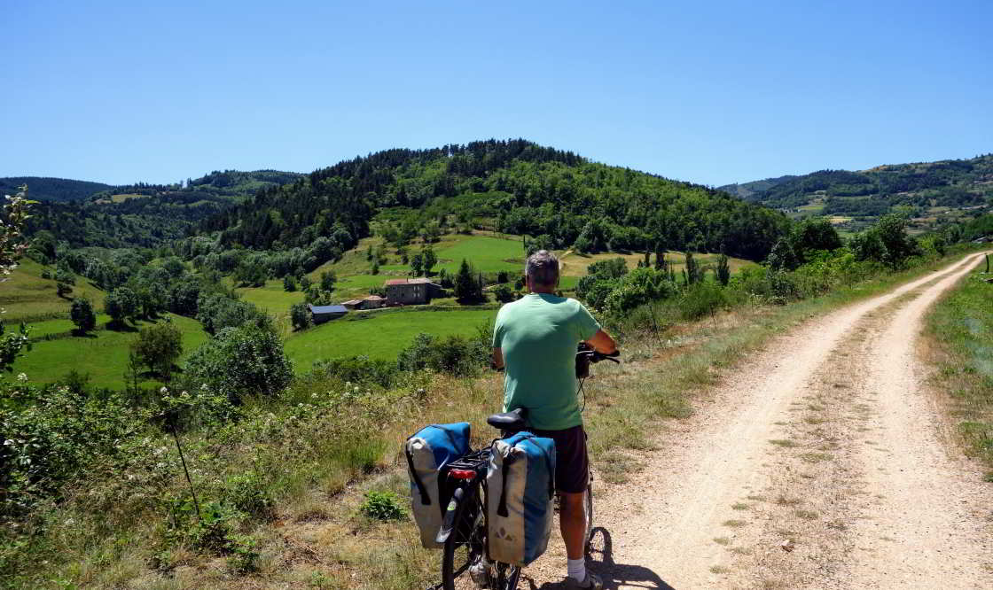 De beloning voor de Dolce Via-fietsers: prachtige uitzichten! fietser kijkt uit over landschap La Dolce Via