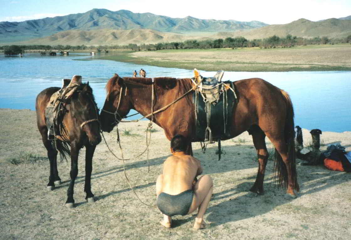 Man met paard in Mongolië Jongen in Mongolië kluistert een paard