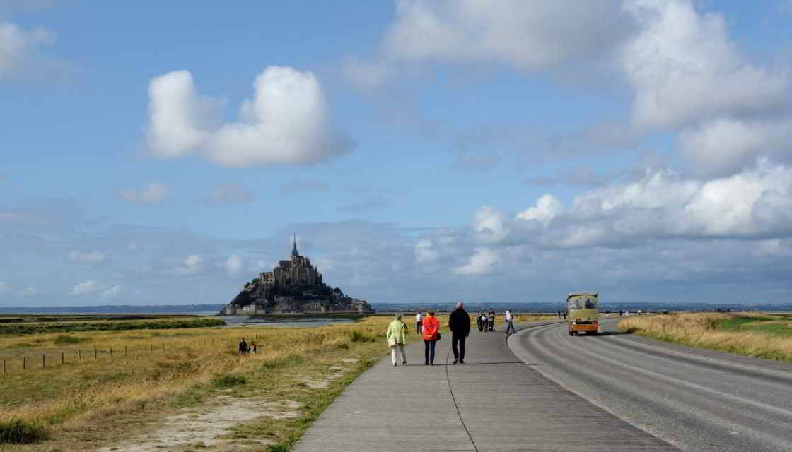 De verhoogde weg naar 'Mont' Wandelaars op de toegangsweg naar de Mont-Saint-Michel