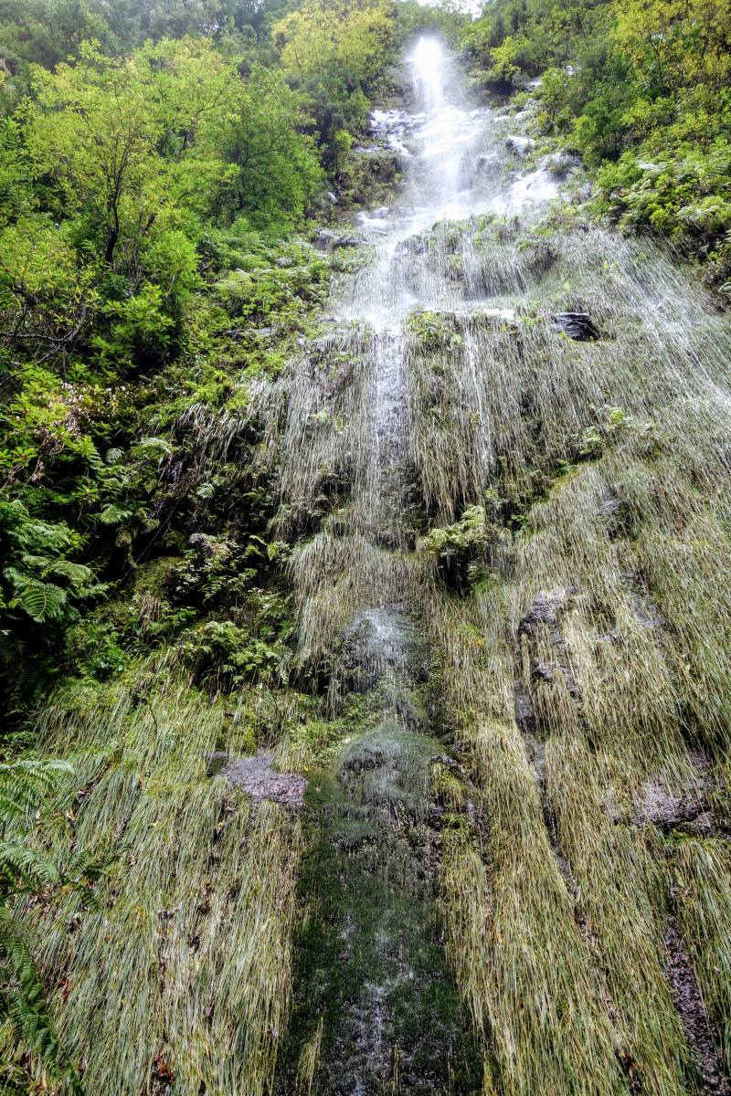 Een regenjas is geen overbodige luxe... Waterval op Madeira stort zich over de rand