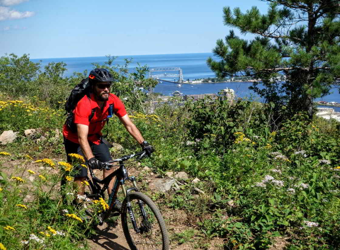 Dave Grandmaison op de Duluth Traverse, op de achtergrond de Aerial Lift Bridge Mountainbiken met uitzicht op de aerial lift bridge