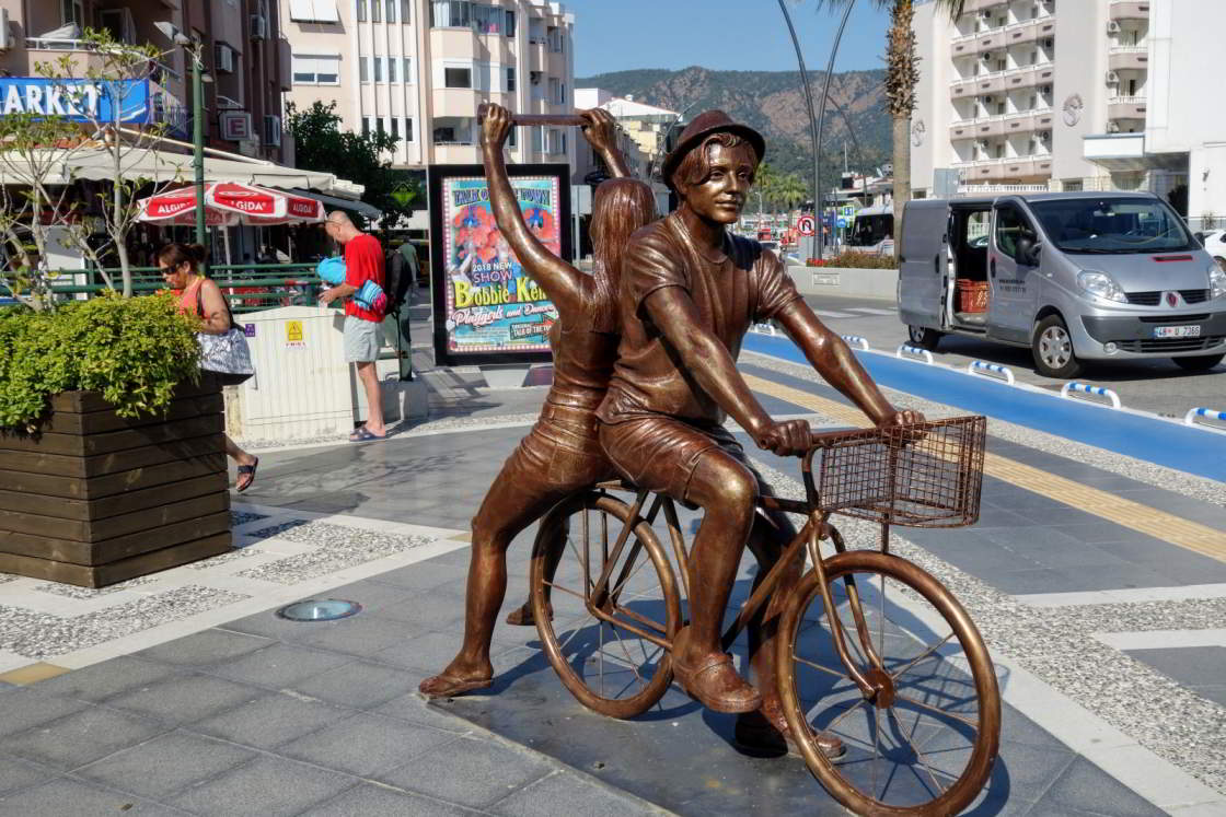 Ode aan de fietser in hartje Marmaris Standbeeld van een fietser met passagier in Marmaris Turkije